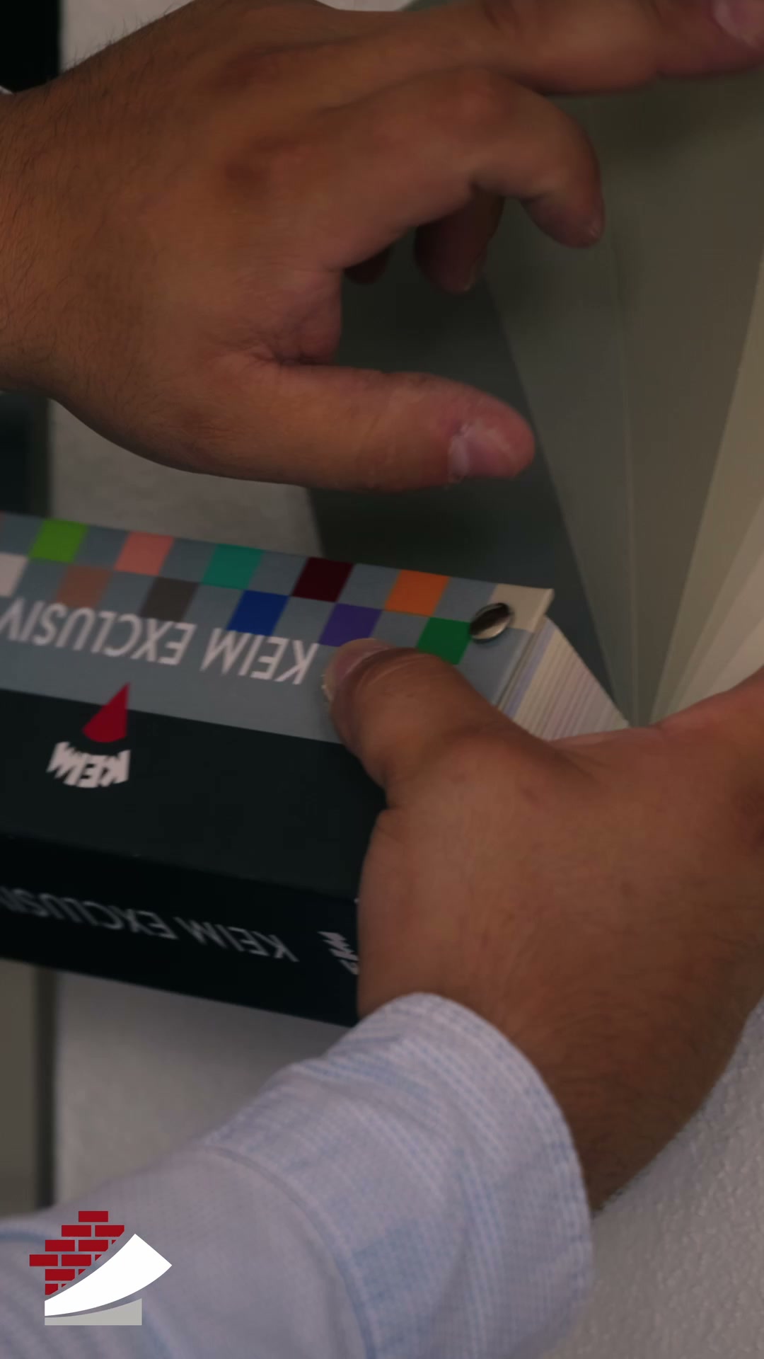 Hände vergleichen Farbmuster für die Gestaltung einer Wand